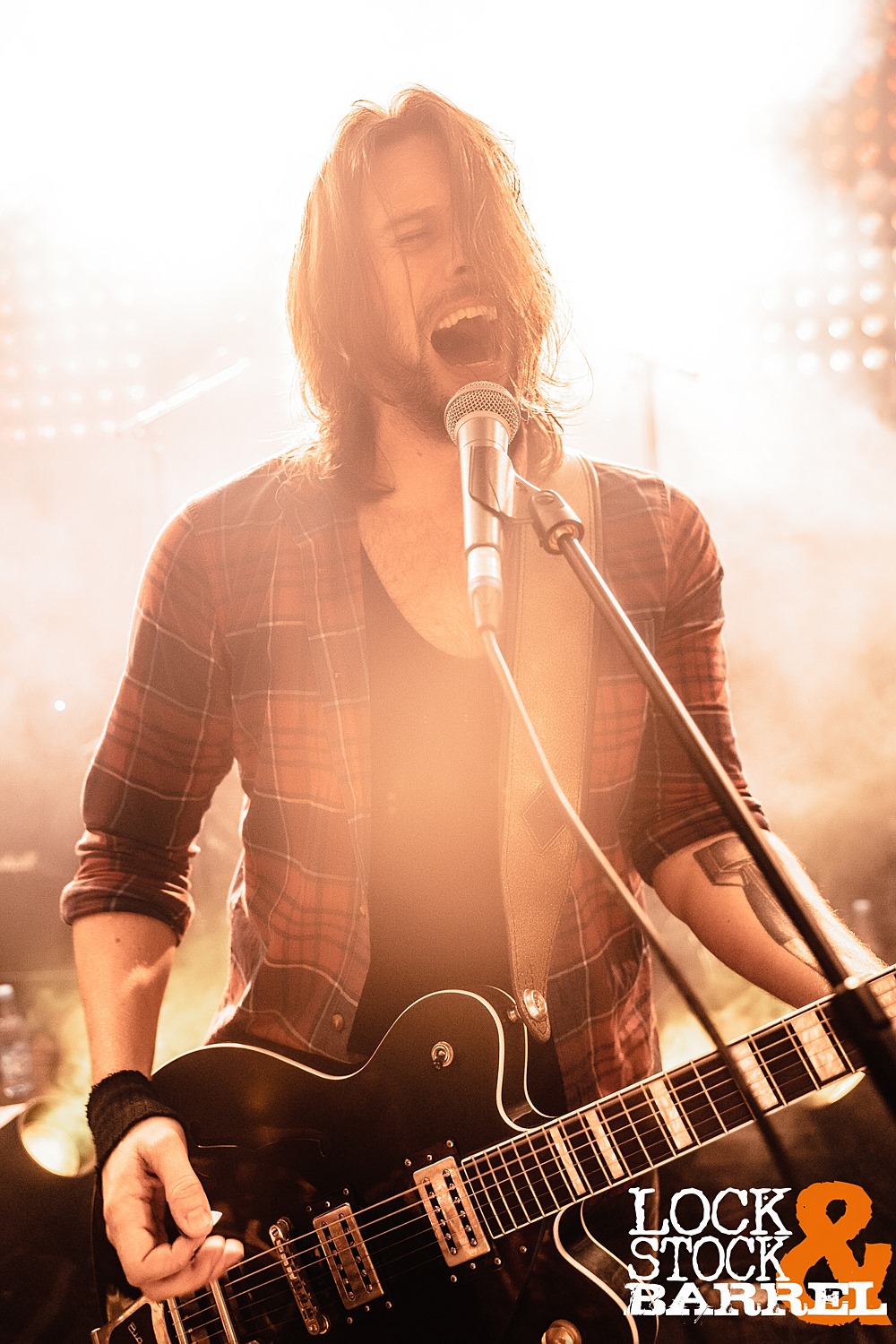 Gaz Hanford singing at the microphone and playing guitar